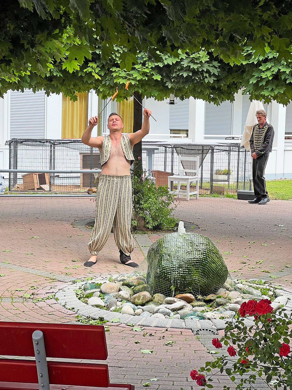 Ein Akrobat hat brennende Stäbe in der Hand