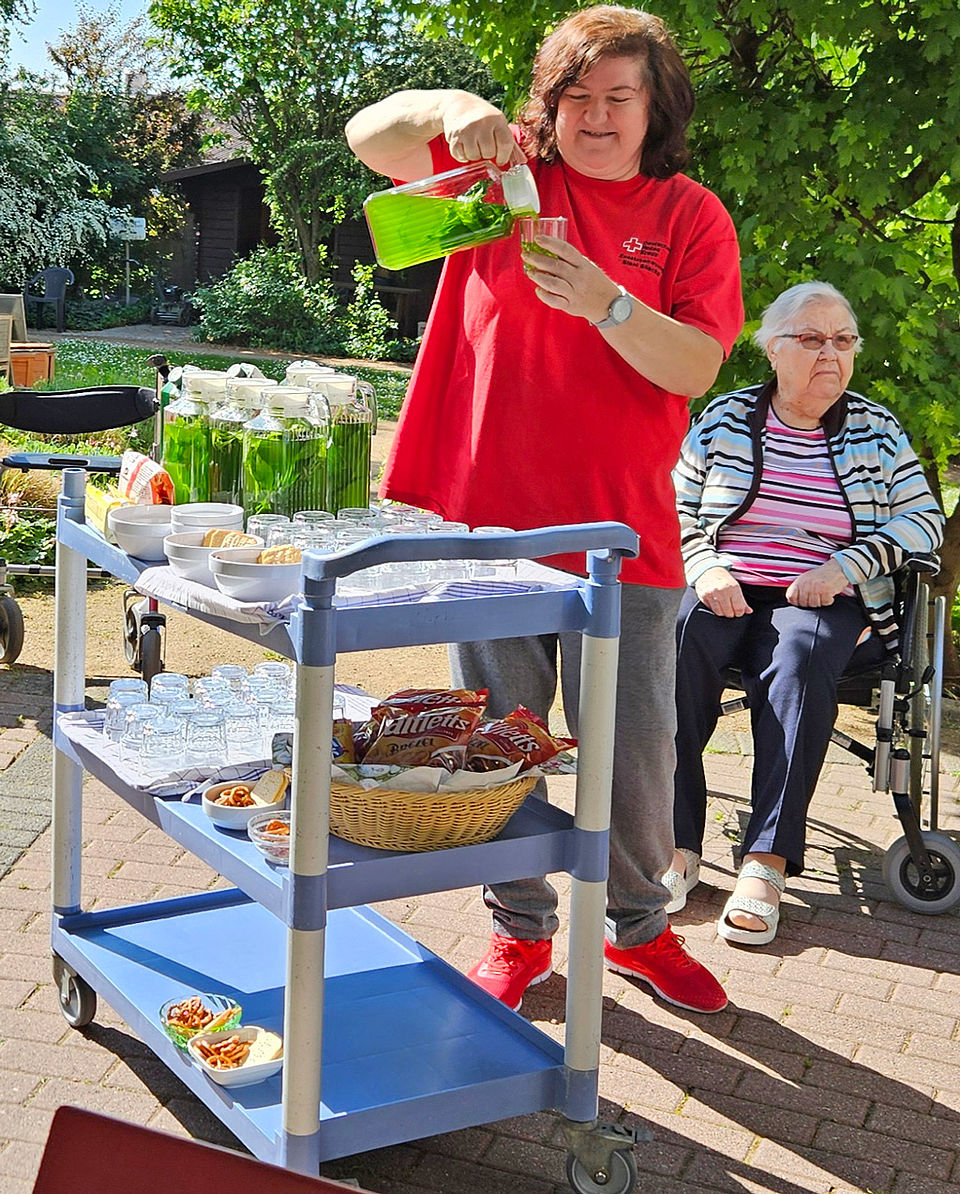 Eine Frau schenkt sich Maibowle ein