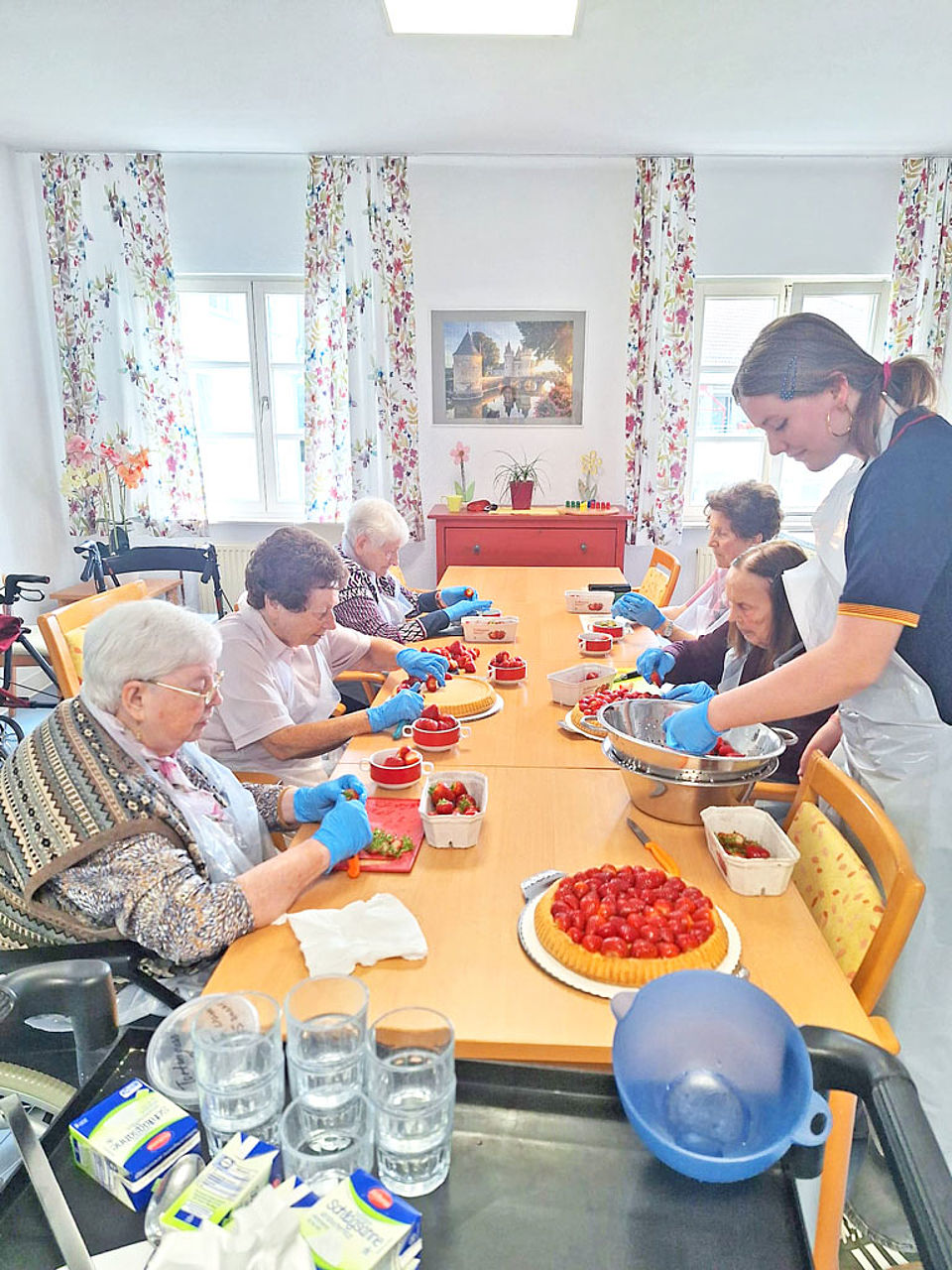 Senioren bereiten zusammen einen Erdbeerkuchen zu