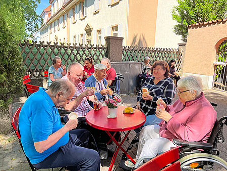 Senioren sitzen im Eiscafe und genießen ihr Eis