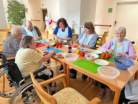 Seniorinnen und Senioren machen zusammen einen Bauernsalat