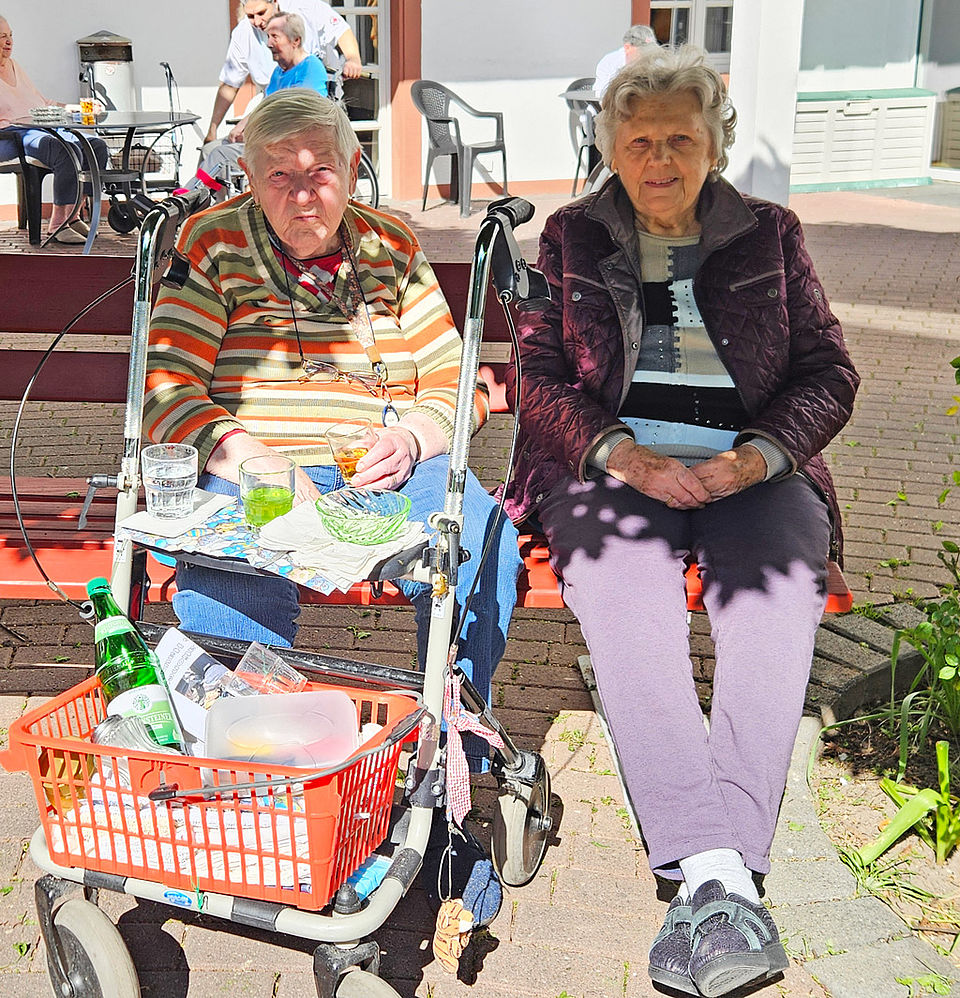 Zwei Seniorinnen sitzen gemütlich im Schatten