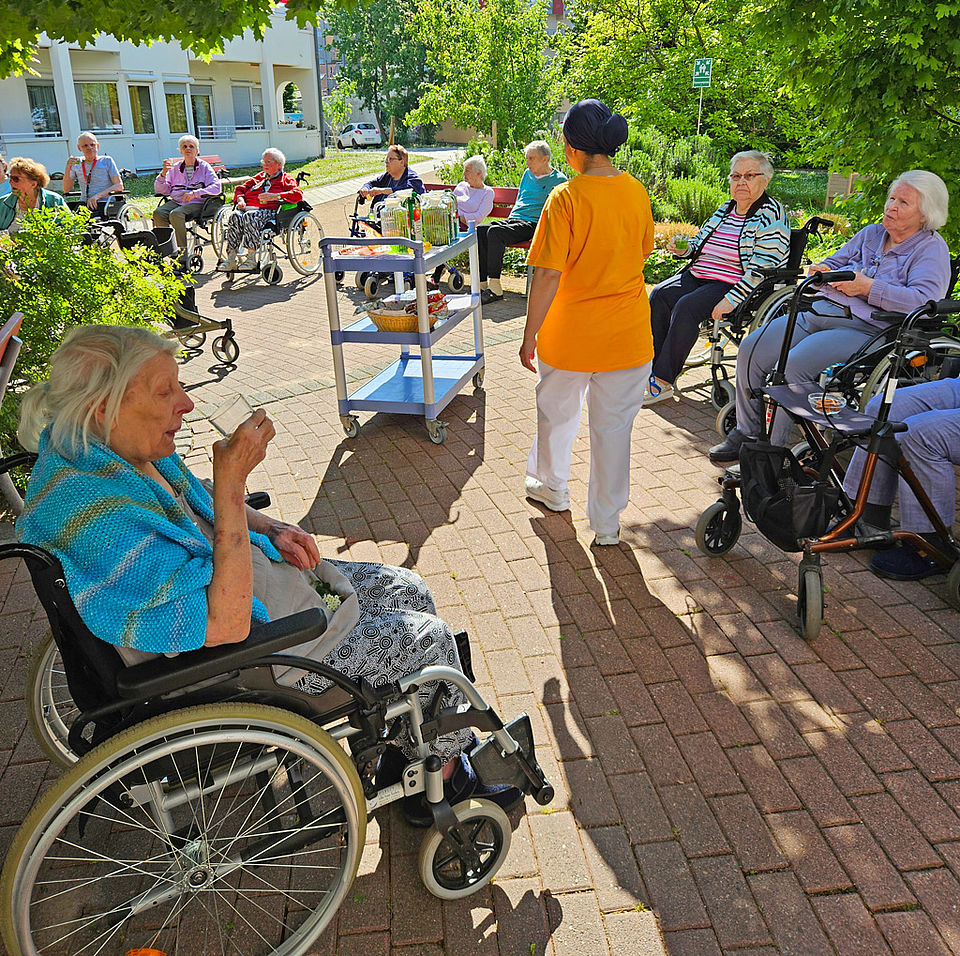 Senioren sitzen im Garten und genießen das Wetter