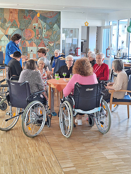 Seniorinnen und Senioren genießen gemeinsam eine Maibowle