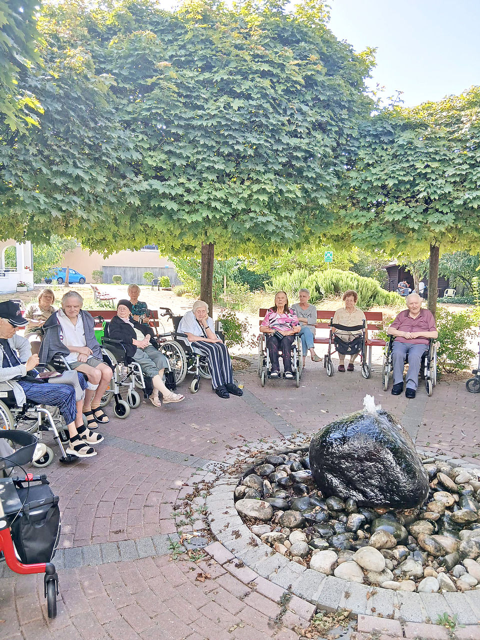 Zusammensitzen Im Garten sitzen viele Seniorinnen und Senioren zusammen um sich zu unterhalten
