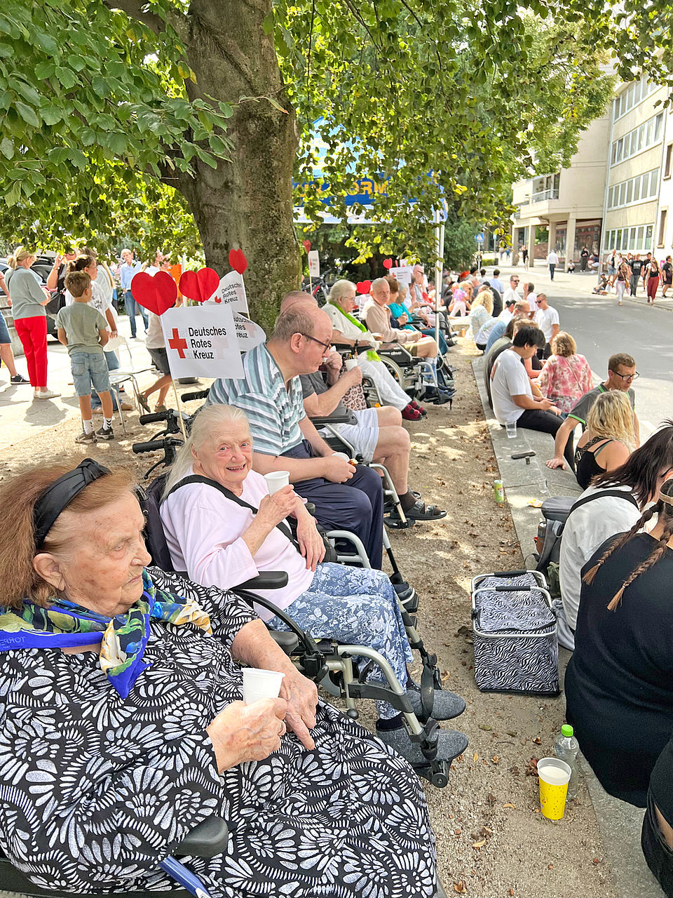Backfischfest Seniorinnen und Senioren sitzen am Straßenrand und warten auf den Festumzug.