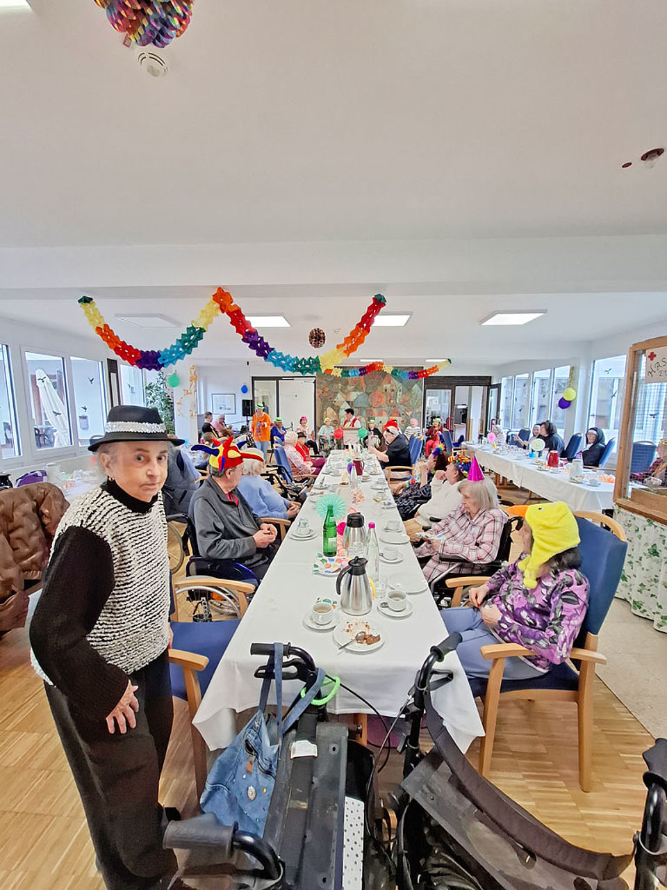 Senioren sitzen verkleidet zusammen bei Kaffee und Kuchen