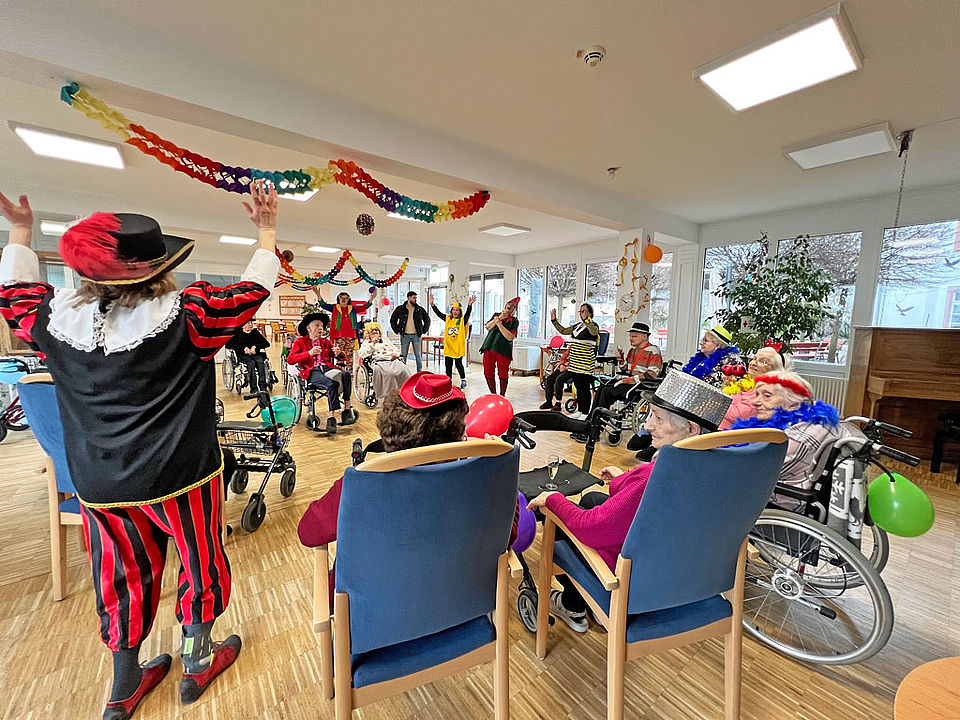 Verkleidete Senioren/Seniorinnen und Mitarbeiterinnen bewegen sich zur Fastnachtsmusik