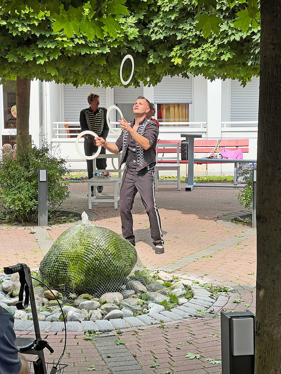 Ein Akrobat jongliert mit kleinen Reifen