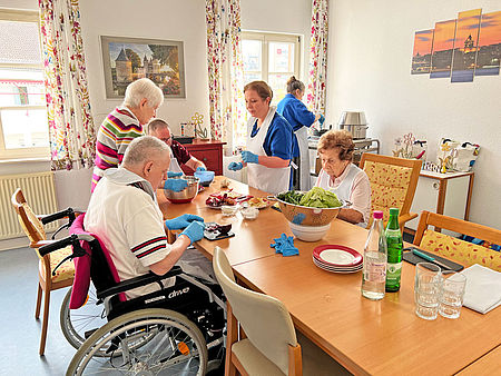 Seniorinnen uns Senioren kochen gemeinsam Frikadellen und Kartoffelpüree