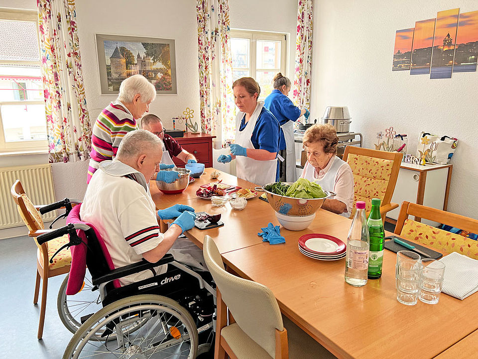 Seniorinnen uns Senioren kochen gemeinsam Frikadellen und Kartoffelpüree